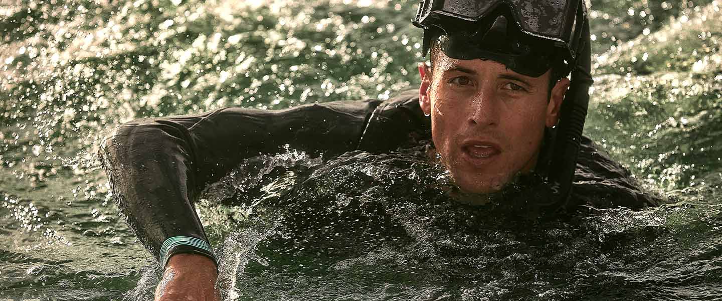 A Navy Aviation Rescue Swimmer navigates through turbulent ocean waves, showcasing skill and resilience during a challenging rescue training exercise.
