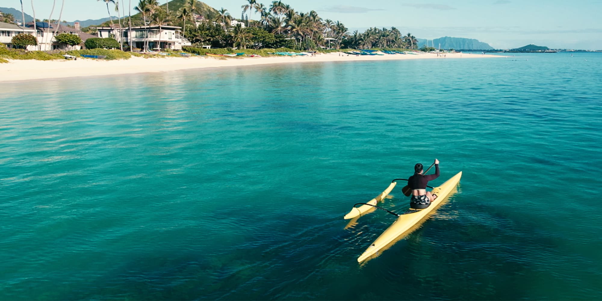 Explore the world with Navy travel benefits & 30 days vacation leave. Girl kayaking in paradise.