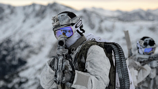 A team of United States Navy Seals in full gear works together during a spec ops training session.