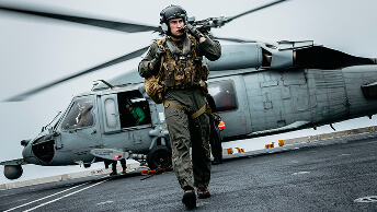 U.S. Navy Helicopter Pilot and Officer disembarks a from an MH-60S Seahawk on the flight deck of the USS George Washington.