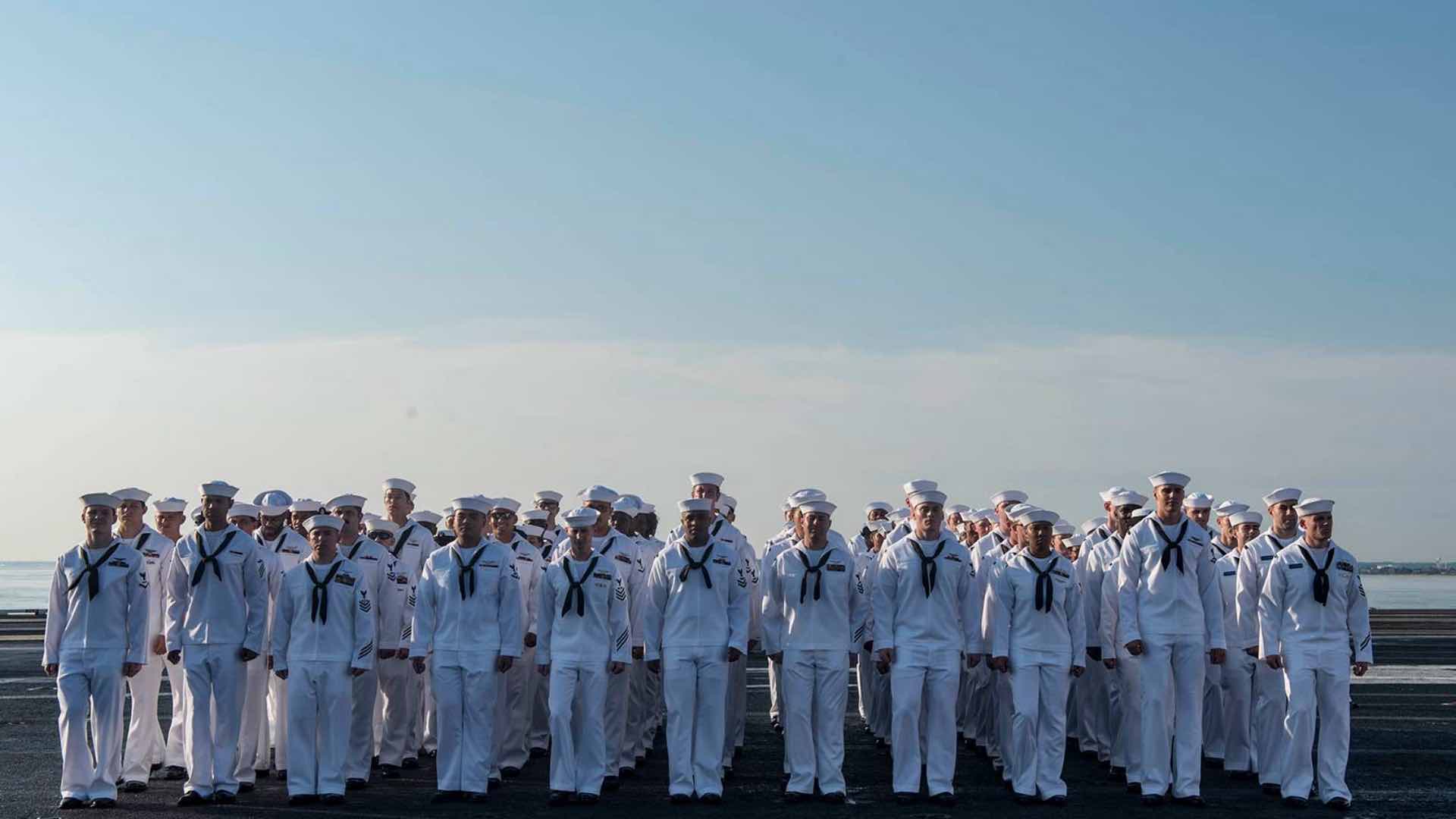 Navy Sailors standing in formation on a flight deck